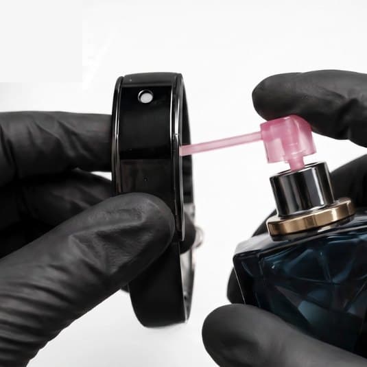 Parfüm wird über den Füllaufsatz in das Armband gepumpt